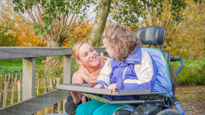 Person im Rollstuhl mit Betreuerin im Park | Getty Images Martinbowra